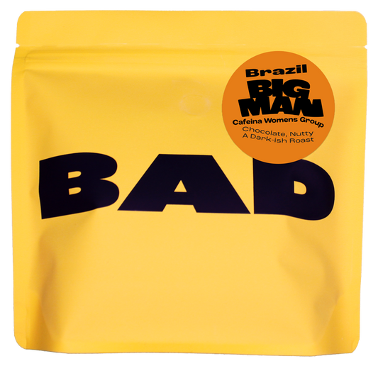 Yellow specialty coffee bag with 'BAD' text and 'Big Man' label "cafeina Womens Group, Brazil"