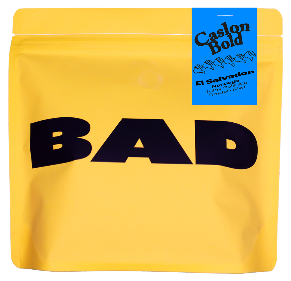 Yellow specialty coffee bag with 'BAD' in black text and a blue label stating "Caslon Bold, El Salvador, Noruega, Juicy Pale Ale and Golden Kiwi"