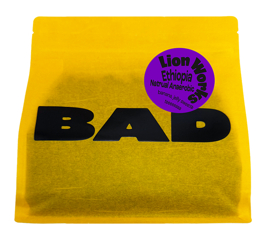 A bright yellow pouch of Lion Works Natural Anaerobic coffee from Ethiopia, with taste notes of jelly sweets, bananas and tea. From Bad Coffee.